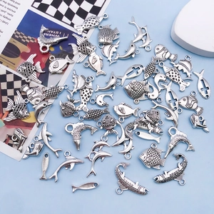 Macro detail of various antique silver ocean fish and dolphin alloy charms for DIY crafting