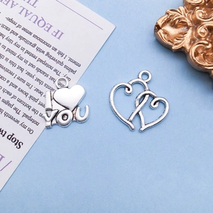 Dettaglio di ciondoli a cuore in argento retrò con incisione I Love You e design cavo