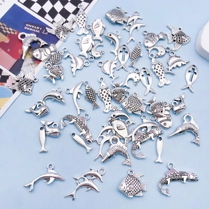 Detailed close-up of mixed silver ocean-themed dolphin and fish alloy charms for DIY
