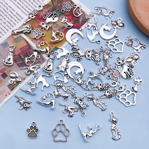 Detailed close-up of antique silver cat charms and paw prints for DIY jewelry making