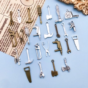 Vue macro de breloques d'outils vintage en bronze et argent pour création de bijoux