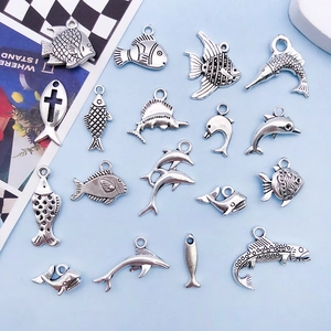 Macro shot of 50 pieces antique silver zinc alloy ocean life charms on blue surface