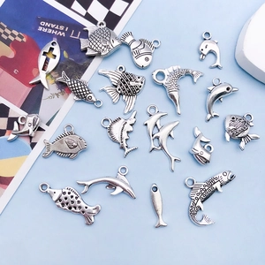Macro view of assorted antique silver sea fish and dolphin charms for DIY jewelry making