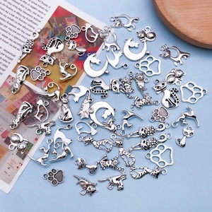 Detailed view of antique silver cat and paw alloy charms for DIY jewelry making and crafts