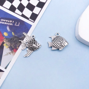 Detailed close-up of antique silver fish charms for DIY jewelry and bracelets