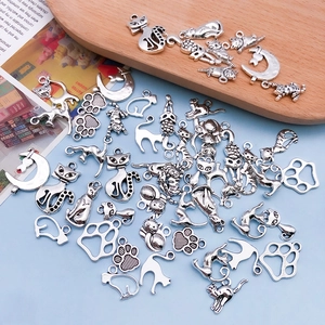 Detailed close-up of antique silver cat and paw alloy charms for DIY jewelry making