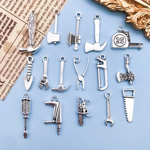 Détail macro de pendentifs outils vintage en alliage argenté, marteaux et clés inclus