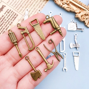 Gros plan de pendentifs outils en alliage bronze et argent pour création de bijoux DIY