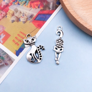 Detailed view of antique silver cat charms and hollow paw print pendants for DIY jewelry