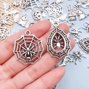 Macro view of vintage silver spider and web alloy charms for DIY Halloween jewelry making