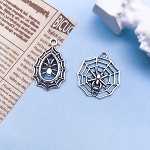 Macro shot of silver vintage alloy spider and web pendants for DIY Halloween jewelry