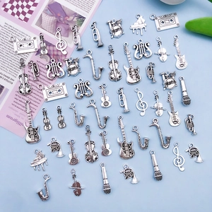 Detailed flat lay of antique silver music instrument charms including guitar and violin