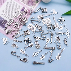 Macro detail of antique silver musical instrument charms including guitar and violin