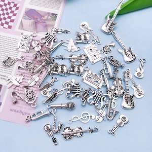 Detailed flat lay of antique silver music charms including guitar, sax and note pendants