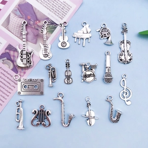 Detailed close-up of antique silver musical instrument charms for DIY jewelry making
