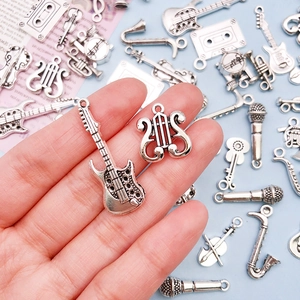Antique silver music instrument charms collection including guitar and violin pendants