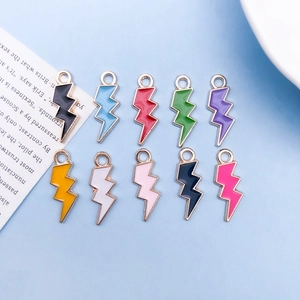 Flat lay of colorful lightning bolt enamel charms with gold edges for DIY jewelry making