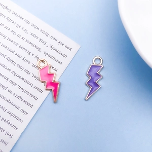 Detailed close-up of pink and purple lightning bolt enamel pendants with metal borders