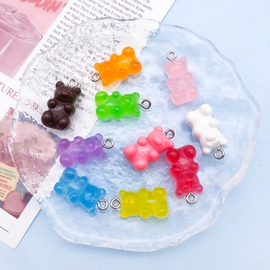 Flat lay of colorful gummy bear resin charms in ten colors on a rippled glass tray