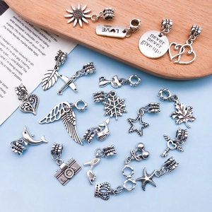 Detailed view of assorted antique silver DIY charms including sunflowers and cameras
