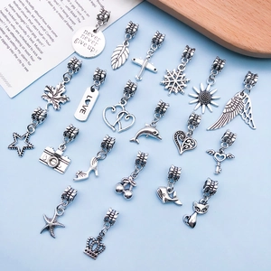 Detailed macro view of assorted vintage Tibetan silver charms for DIY jewelry bracelets