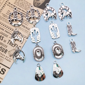 Macro shot of vintage silver cowboy charms including boots, hats, and horseshoes for DIY
