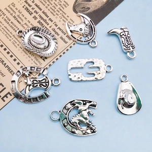 Macro view of vintage silver cowboy charms including boots, hats and horseshoes