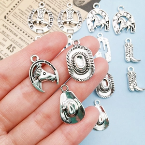 Macro view of vintage silver cowboy charms including boots and hats for DIY jewelry