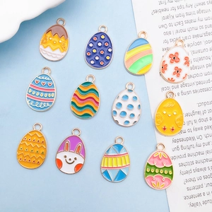 Detailed macro view of 12 Easter egg charms with rabbit and floral enamel patterns