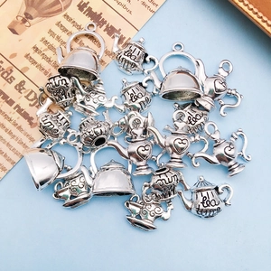 Nahaufnahme von Vintage Teekannen-Anhängern aus Silber für DIY-Schmuck mit Tea Time Gravur