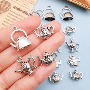 Makroansicht von Vintage Silber Teekanne Anhängern für Schmuck in der Hand gehalten