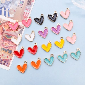 Detail of colorful enamel heart pendants with gold dotted borders for DIY jewelry making