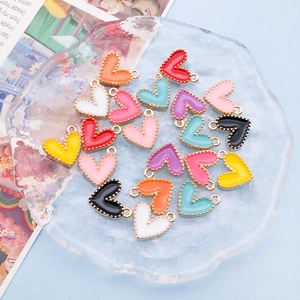 Macro detail of colorful heart enamel charms with gold beaded edges for DIY jewelry making