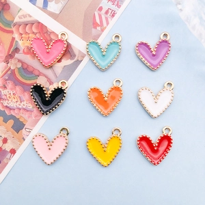 Macro shot of colorful enamel heart charms with gold beaded edges for DIY jewelry making