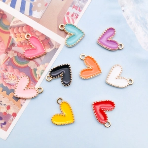 Macro shot of colorful enamel heart charms with golden beaded edges on blue background