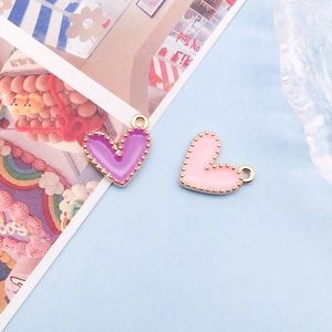 Detail of purple and pink enamel heart charms with gold beaded edges for DIY jewelry