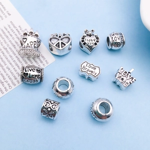 Detailed macro view of vintage silver alloy charms with LOVE and PEACE engravings