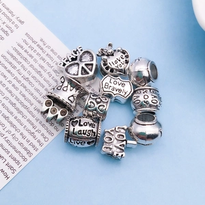 Macro shot of vintage silver alloy large hole beads with engraved LOVE and heart patterns