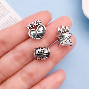 Close-up of vintage silver alloy heart beads with engraved inspirational English words