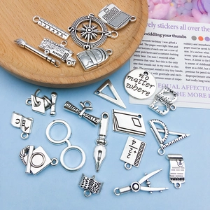 Collection of antique silver school charms like bus, cap, and school bag for DIY jewelry