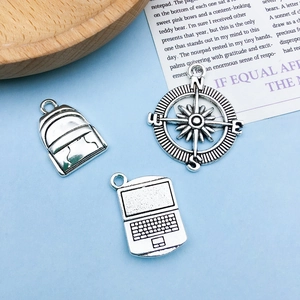 Detailed antique silver graduation charms featuring laptop, backpack and compass designs