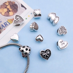 Detailed view of assorted antique silver heart charms with Love and Valentine engravings
