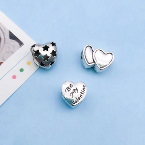 Detailed macro view of heart-shaped alloy charms with Be My Valentine engraving and star cutouts