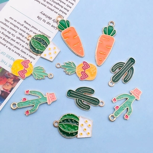 Macro detail of enamel plant pendants like carrot and pineapple for DIY jewelry making