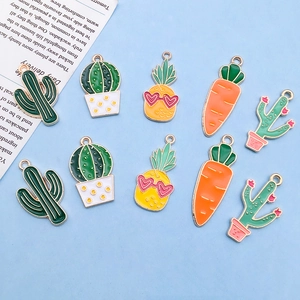 Flat lay of colorful enamel alloy charms featuring cactus, pineapple and carrot designs