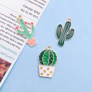 Detailed view of cactus-themed enamel charms in green and gold alloy finishes