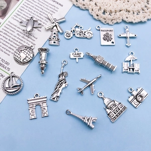 Macro view of vintage silver travel charms featuring world landmarks and camera icons