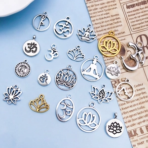 Detailed macro view of antique gold and silver yoga lotus charms for DIY jewelry making