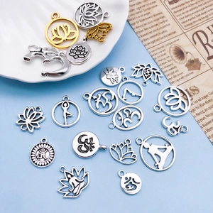 Close-up of vintage silver yoga lotus and Om pendants for DIY jewelry crafting