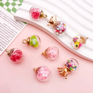 Close-up of DIY glass pendants with colorful stars, fruit slices and gold crown caps